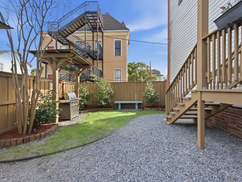 The Wilder House private deck Savannah — bistro table orange juice morning breakfast with garden tree views