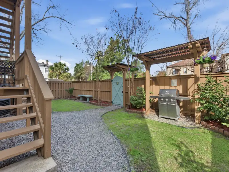 The Wilder House shared backyard Savannah — gas grill under pergola green lawn and private courtyard Victorian District